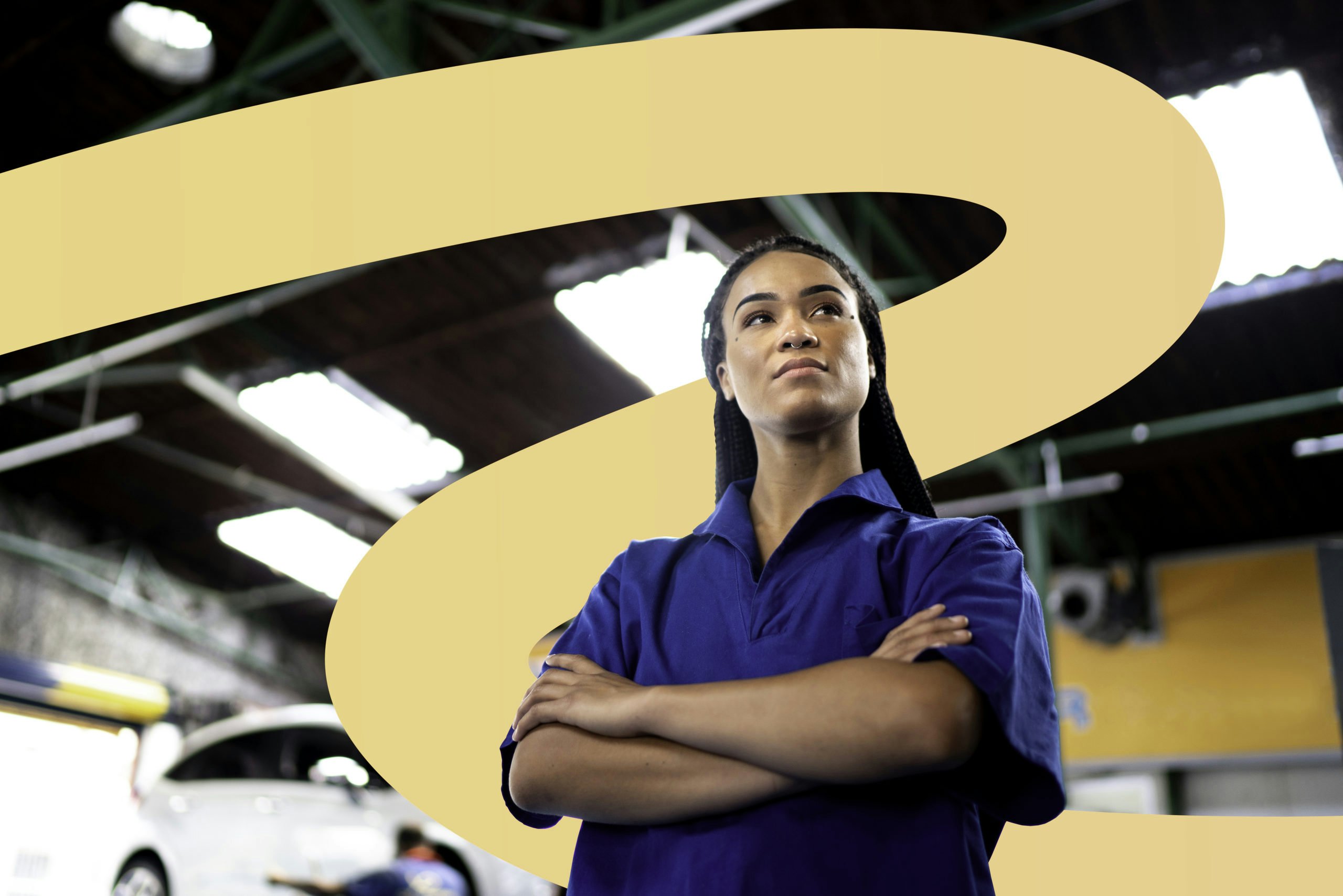 Low angle of a confident mechanic standing with arms crossed, looking away